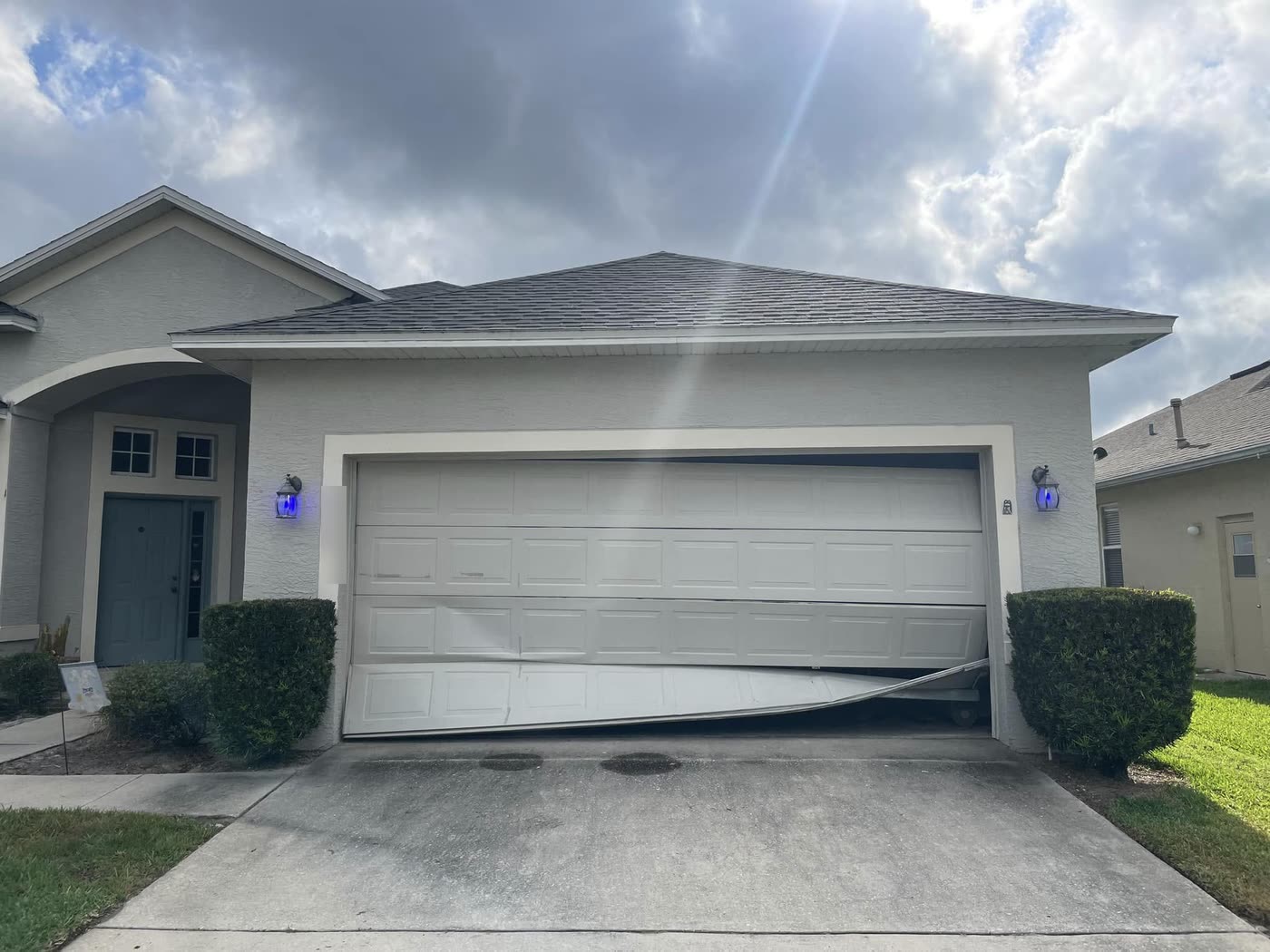 The same garage before, with caved bottom panels and the door off its track