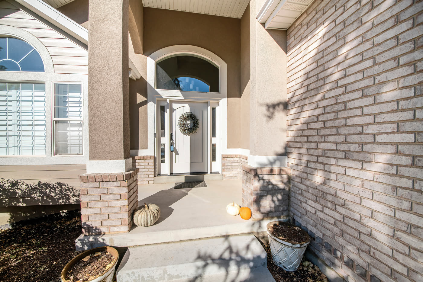 A front entry with an arched transom above the door and sidelights
