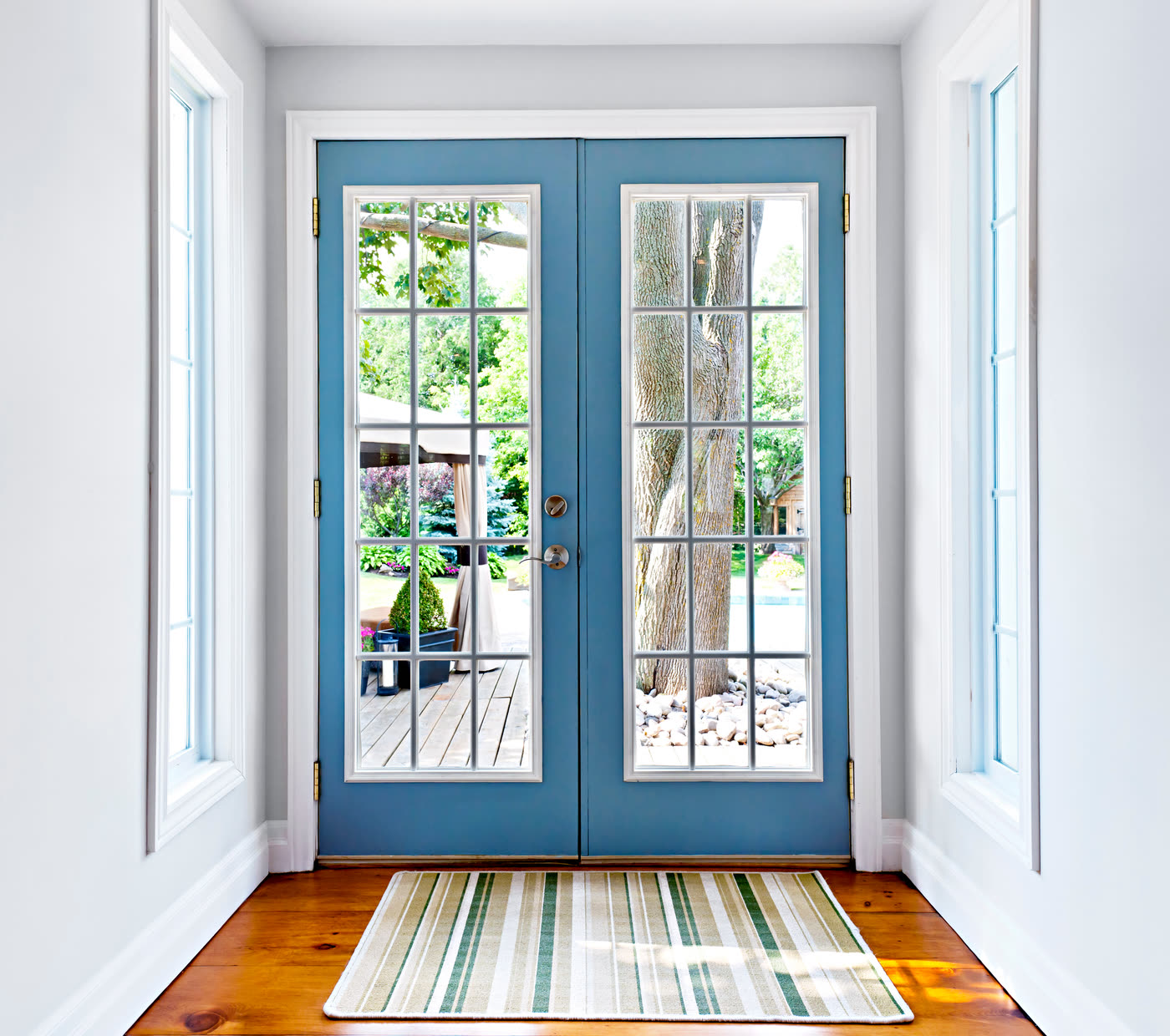 Blue French doors with divided lights opening onto a garden